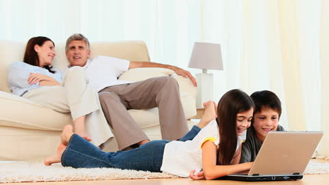 Happy Family Relaxing Together with Laptop