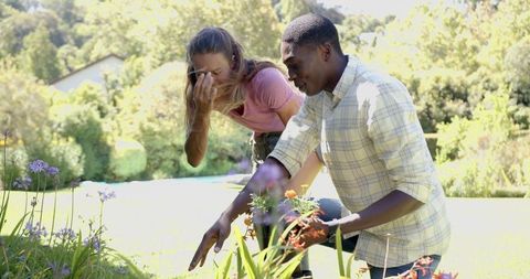 Diverse couple bonding while gardening together in serene backyard - Download Free Stock Images Pikwizard.com