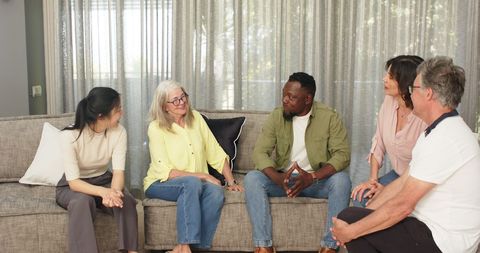 Diverse therapy group engaging in supportive conversation