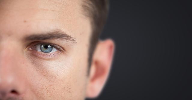 Close-up image features a man's face highlighting his blue eyes against a dark grey background. Ideal for use in advertising, personal development articles, counseling resources, and websites focusing on health, skincare, eye care, emotions, human psychology, or masculinity studies.
