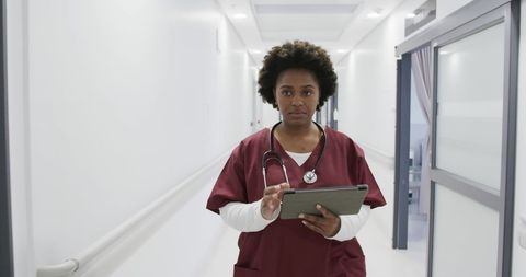 Confident Female Doctor Using Tablet in Hospital Corridor - Download Free Stock Images Pikwizard.com