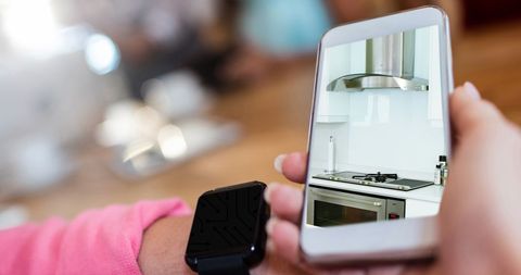 Person Using Smartphone for Kitchen Interior Design Inspiration