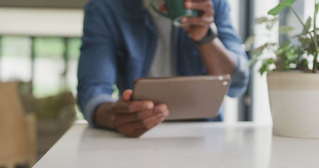 Man drinking coffee while using tablet in modern kitchen - Download Free Stock Images Pikwizard.com