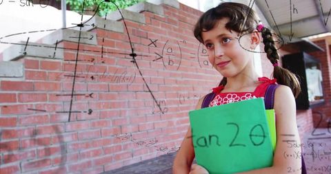 Smiling schoolgirl with notebook among mathematical drawings