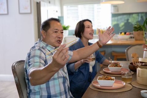 Asian Couple Enjoying Casual Lunch with Chopsticks at Home