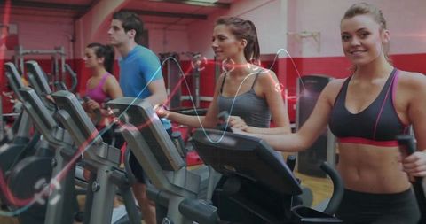 People Enjoying Workout on Elliptical Machines in Gym
