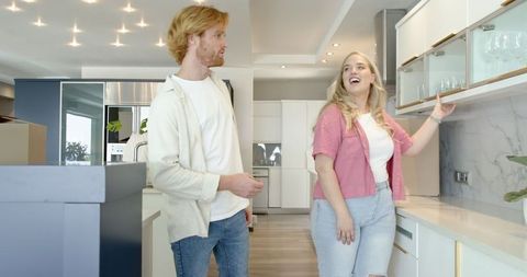 Happy couple touring new home kitchen interior