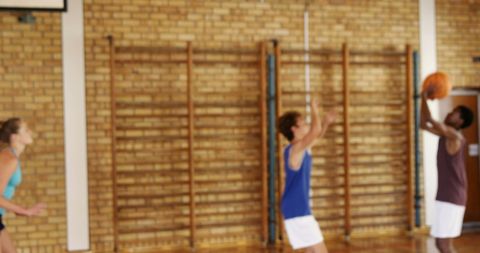 Enthusiastic Teens Playing Basketball in School Gymnasium