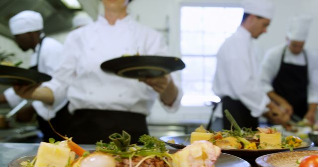 Chefs in a professional kitchen plating gourmet dishes with careful attention to detail. Ideal for content related to culinary arts, restaurant industry, team collaboration, food preparation, and gourmet cooking.