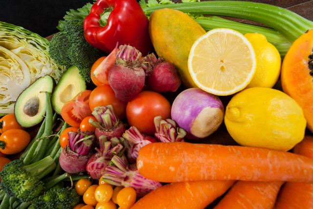 Colorful assortment of fresh vegetables including avocado, carrots, broccoli, tomatoes, peppers, and citrus. Great for articles, blogs, and websites promoting healthy eating, nutrition, and vegetarian lifestyles.