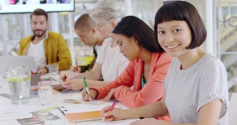 Smiling Asian Woman in Busy Collaborative Workspace - Download Free Stock Images Pikwizard.com