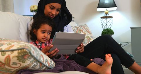 Young Mother and Daughter Using Tablet on Cozy Sofa