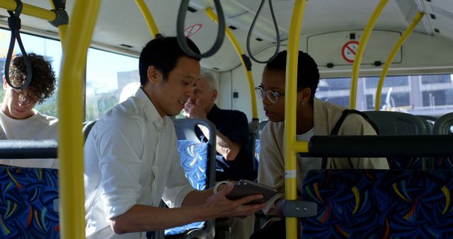 Diverse couple sitting in city bus using tablet. Communication, transport, city living and lifestyle, unaltered.
