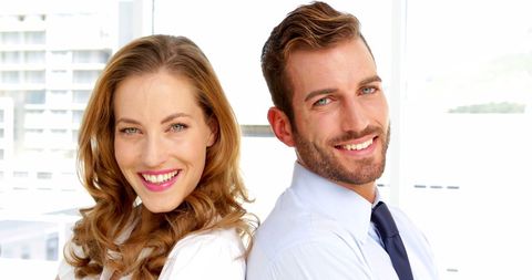 Confident Business Professionals Smiling in Modern Office