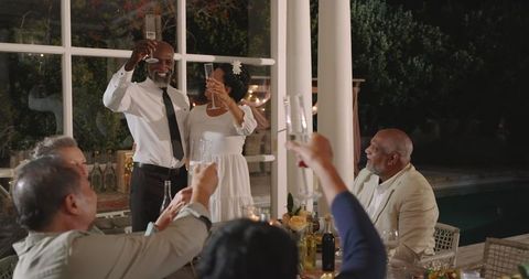 Senior diverse couple celebrating at elegant outdoor wedding reception