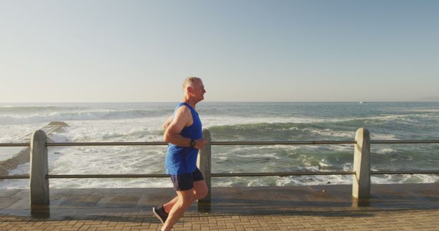 Senior Man Jogging by Ocean with Blue Sky in Background - Download Free Stock Images Pikwizard.com