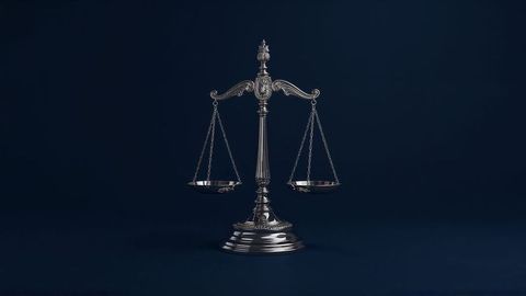 Ornate metallic balance scale on dark blue background