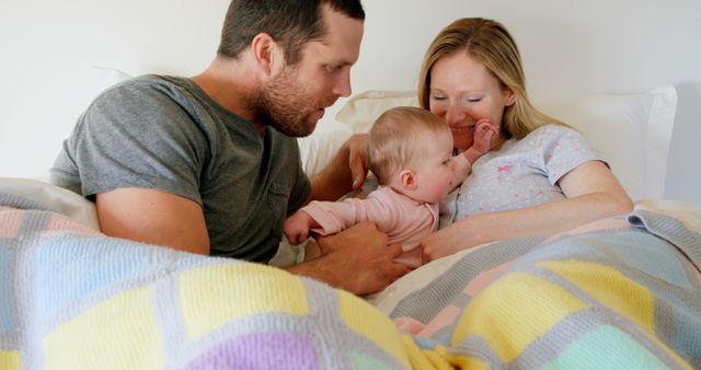 Happy Parents Playing with Young Baby Daughter in Bed - Download Free Stock Images Pikwizard.com