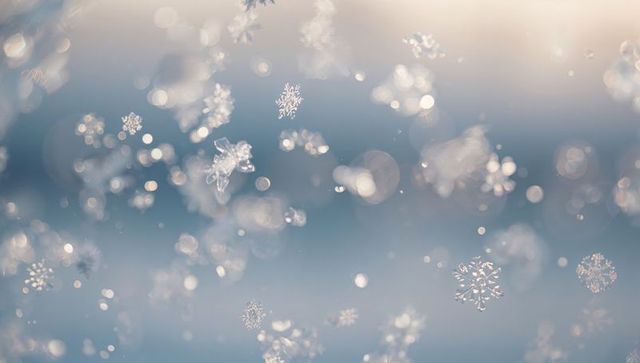 Drifting snowflakes sparkling in dawn bokeh, frosted ice crystals macro backlit winter morning
