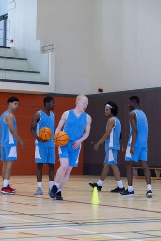 Diverse Basketball Team Preparing Drill in Gymnasium