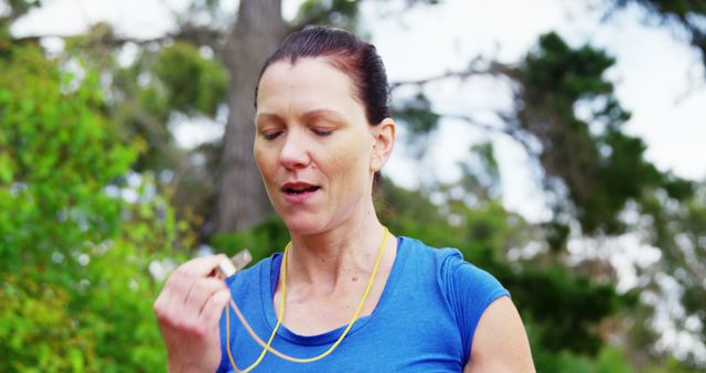 A middle-aged Caucasian woman is jogging outdoors, taking a break to catch her breath, with copy space. Her focused expression and sporty attire suggest a commitment to fitness and an active lifestyle.