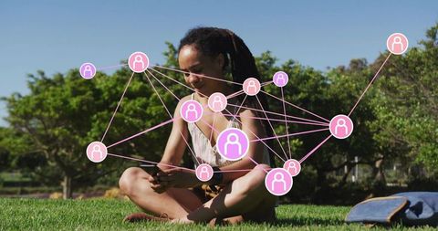 Woman connecting digitally outdoors using mobile device on grass