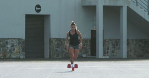 Female track runner starting from block on track