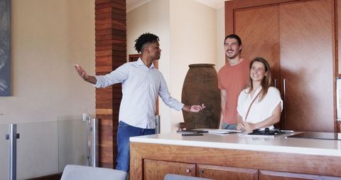 Young couple engages with real estate agent in modern kitchen