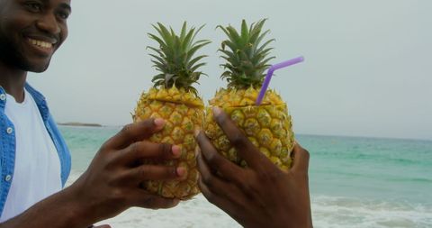Joyful Couple Toasting Pineapple Drinks at Beachfront - Download Free Stock Images Pikwizard.com