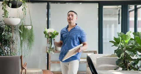 Man entering office with bouquet and picture frame