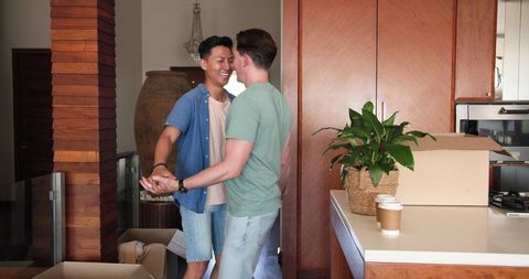 Joyful Couple Dancing in New Home Amid Moving Boxes