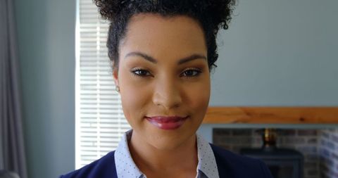 Confident professional woman in business attire smiling indoors