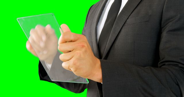 Businessman Interacting with Transparent Tablet on Green Background - Download Free Stock Images Pikwizard.com