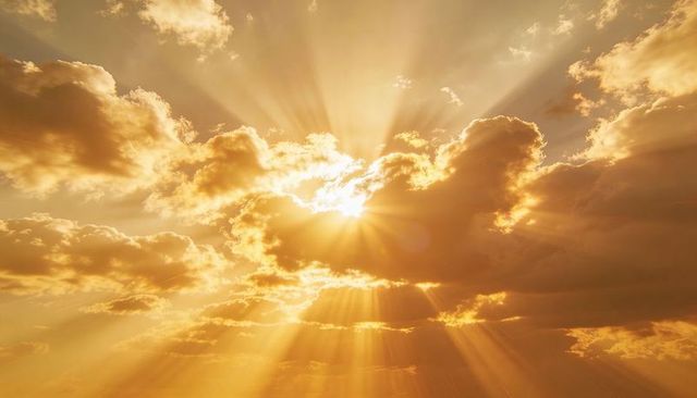 Golden sunburst breaking through cumulus clouds, dramatic crepuscular rays at horizon