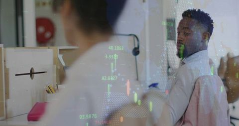 Turning professional looking over shoulder in open office with candlestick charts overlay