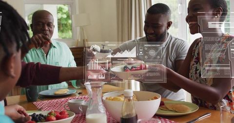 Multigenerational black family sharing pancake breakfast with augmented reality overlays