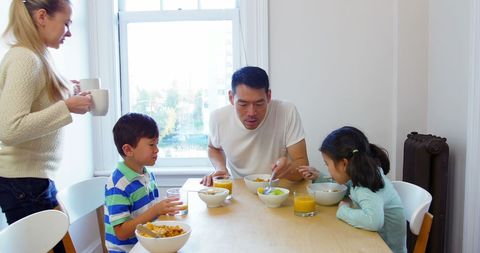 Family Enjoying Breakfast at Home in Sunlit Kitchen