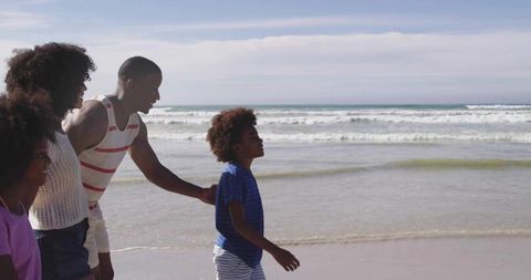 Family Enjoying Walk by the Beach with Ocean Waves