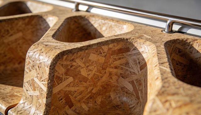 Molded osb organizer with rounded cavities, varnish sheen and metal rail closeup texture