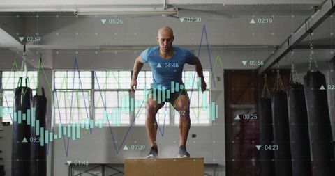 Male athlete performing explosive box jump with fitness analytics overlay in gym