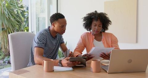 African american couple at home reviewing documents together