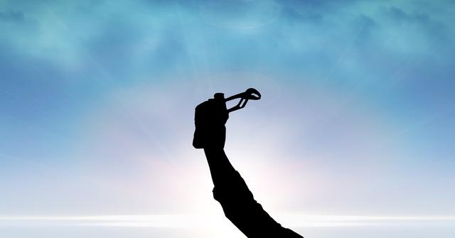Digital composite of Silhouette hand holding tool against sky