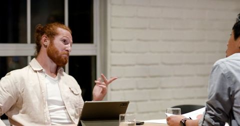 Businessmen collaborating over technology on strategy planning