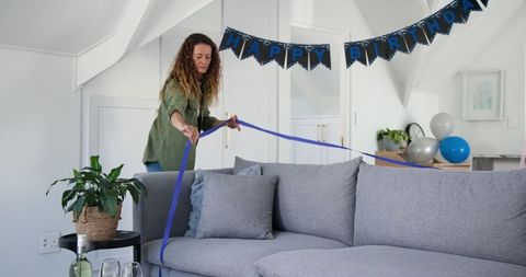 Woman Decorating Living Room for Birthday Celebration