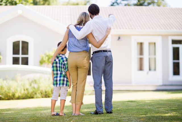 Family standing together in front of their new home, symbolizing homeownership and unity. Ideal for real estate advertisements, family lifestyle promotions, and home improvement campaigns.