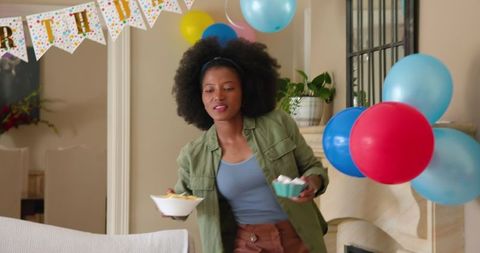 Woman Preparing Food for Child's Birthday Celebration in Decorated Room
