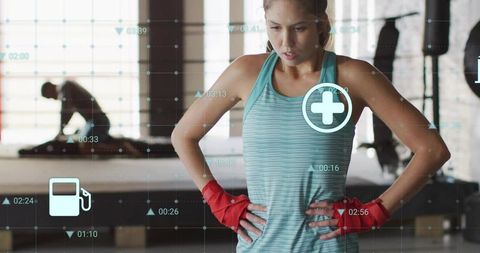 Female Boxer Monitoring Performance with HUD Wearable Tech in Industrial Boxing Gym