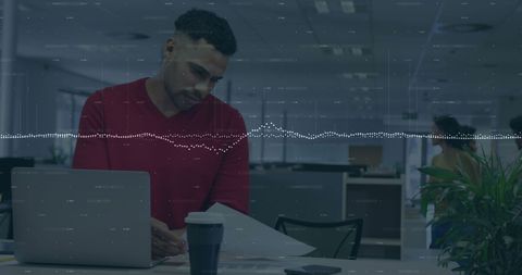 Businessman analyzing financial data with laptop in office