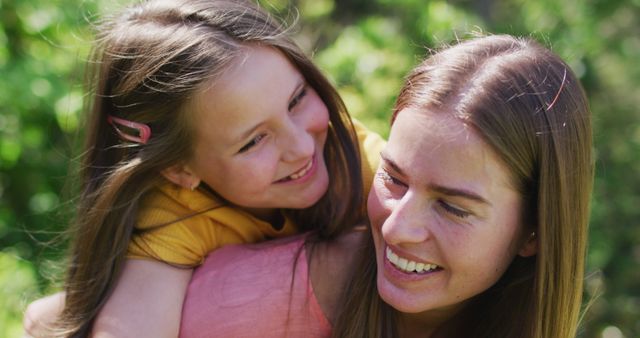 Smiling Mother Carrying Daughter in Sunny Garden - Download Free Stock Images Pikwizard.com