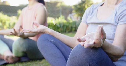 Mother and Daughter Practicing Yoga Meditation Outdoors in Garden